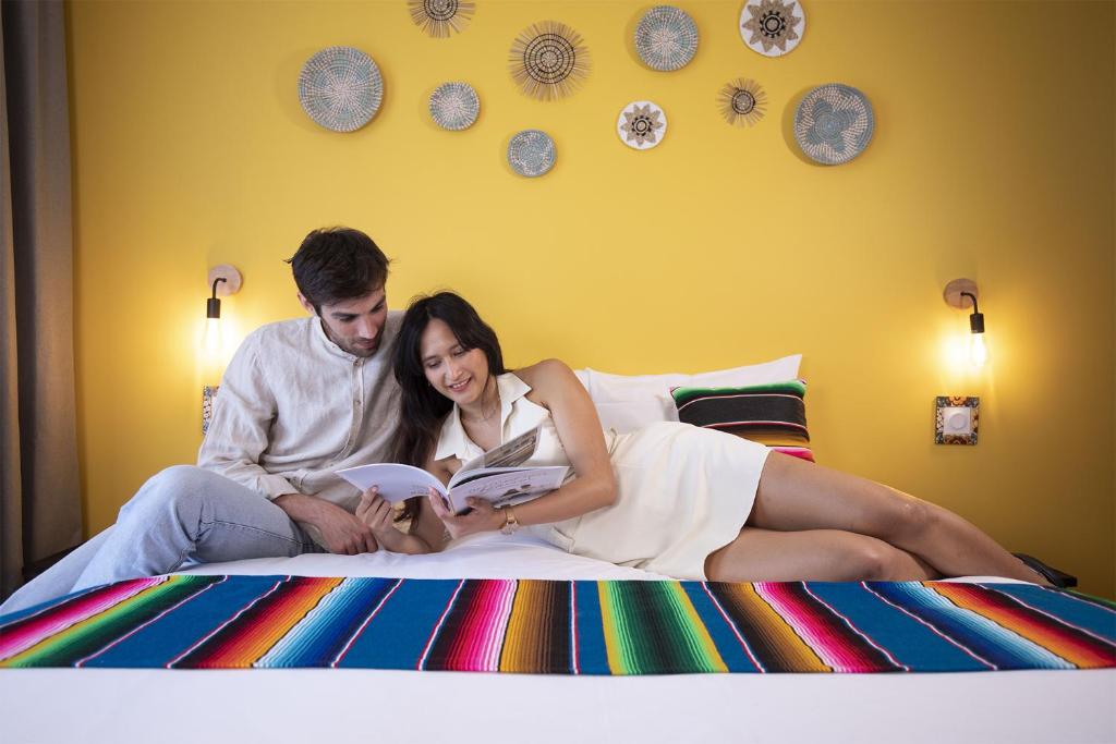 un homme et une femme assis sur un lit en lisant un livre dans l'établissement Les Rivages de Beauval, à Saint-Aignan