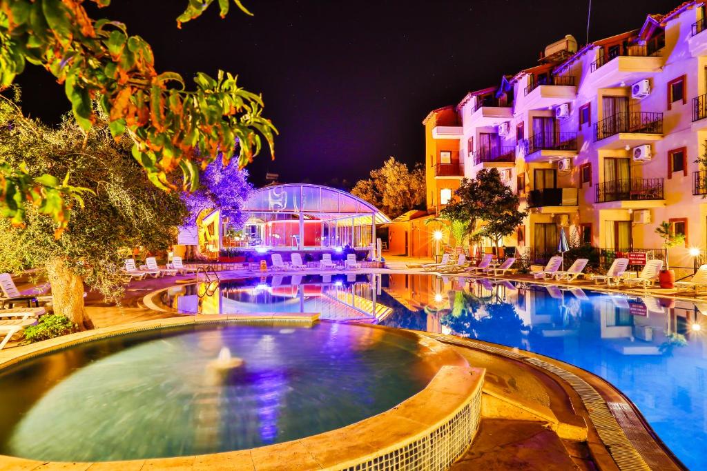 a swimming pool in a resort at night at Club Hotel Gultur in Kucukkuyu