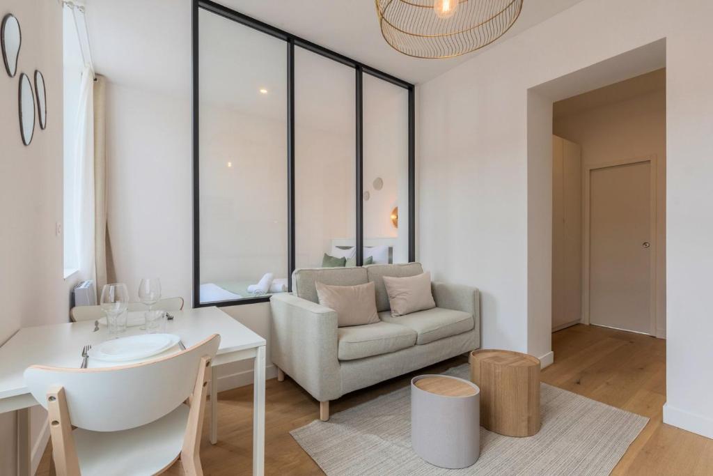 un salon avec un canapé et une table dans l'établissement Grand studio rénové, proche tram, à Tourcoing
