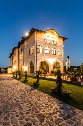 a large building is lit up at night at Country SPA Village in Ciofliceni