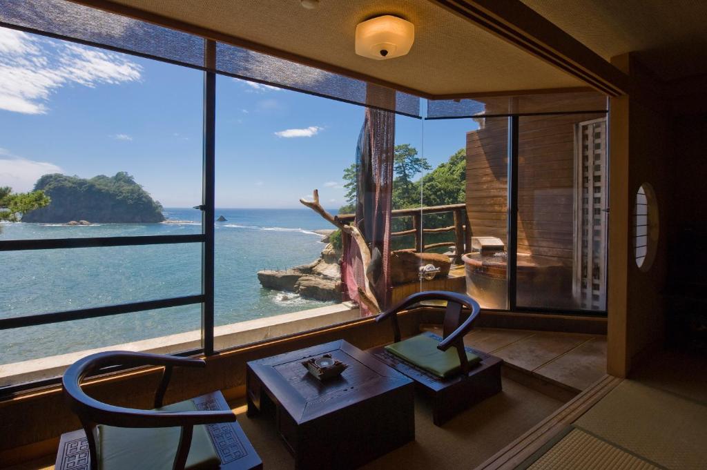 Zimmer mit einem großen Fenster und Meerblick in der Unterkunft Umibenokakureyu Seiryu in Nishiizu