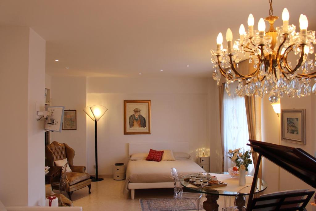 a living room with a bed and a chandelier at L'Attico del Centro in Matera