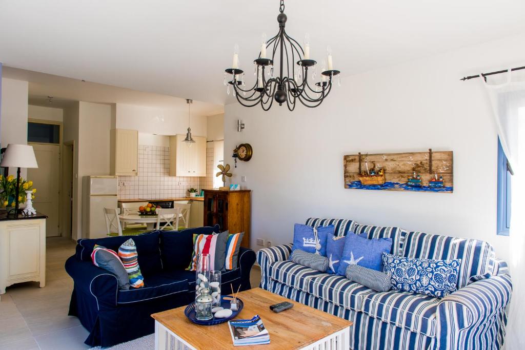 a living room with two blue couches and a table at Eva's House in Stroumbi