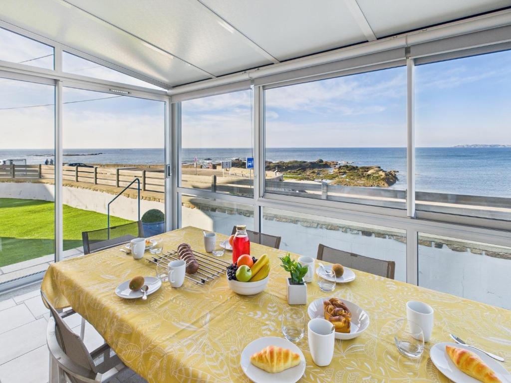 une salle à manger avec une table avec vue sur l'océan dans l'établissement -AVEL DRO- Belle maison familiale vue mer corniche, à Concarneau