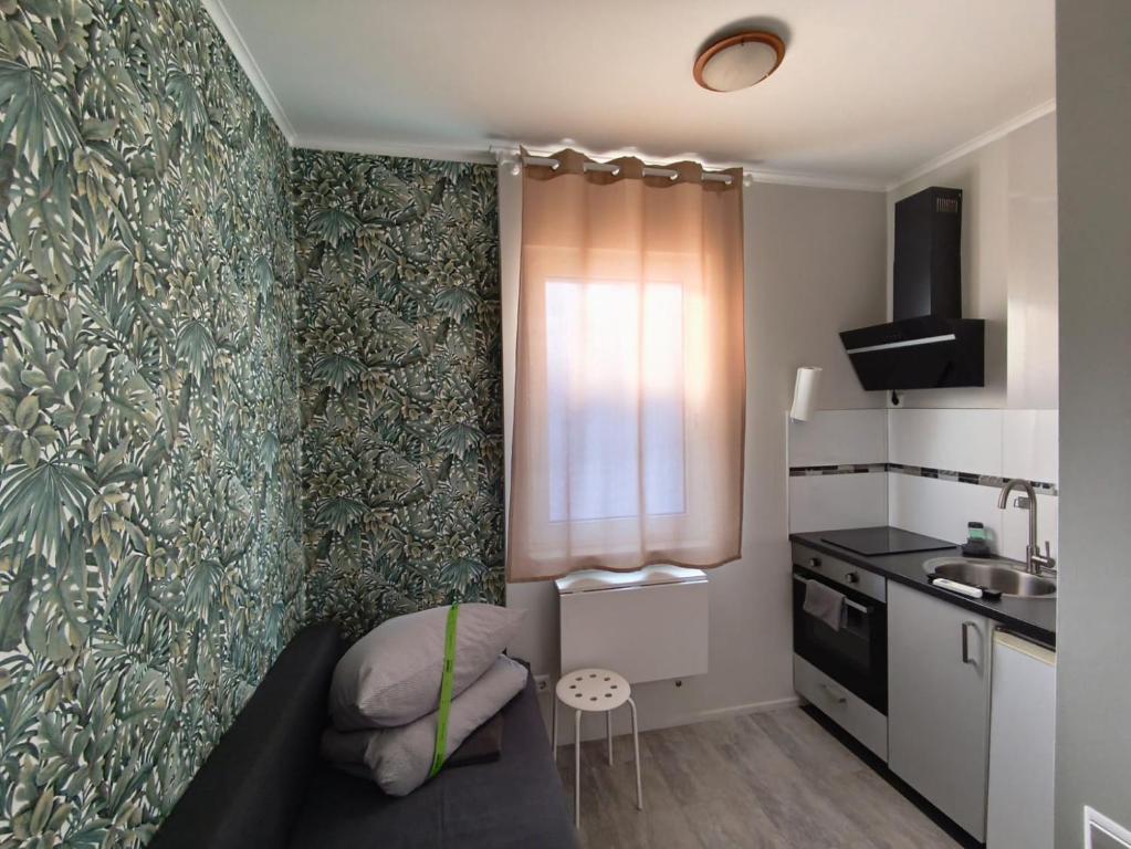 a small room with a couch and a kitchen at Neuwertiges Apartment mit schnellem WLAN, Glasfaser, R7 in Freiberg am Neckar