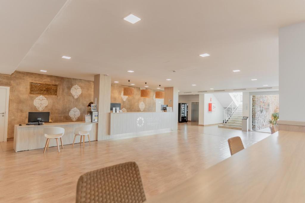 an empty lobby with a table and chairs and a counter at Minura Sur Menorca in Punta Prima