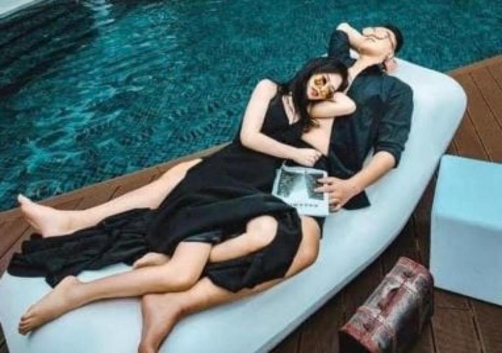 a man and a woman laying on a raft next to a pool at The Cove Premium Suites 7-13pax by IWH Suites in Ipoh
