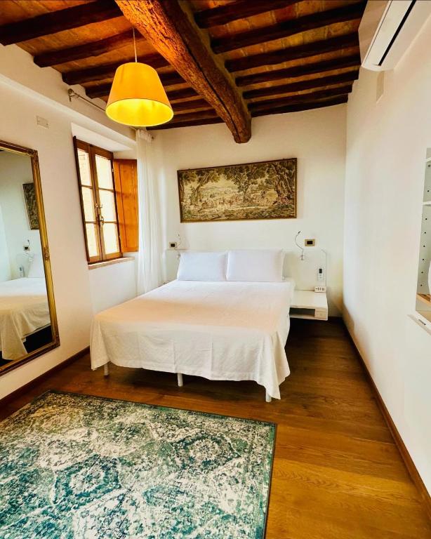 a bedroom with a white bed and a rug at TRUFFLE'N'BED in San Giovanni dʼAsso
