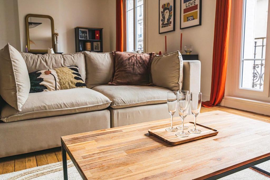 - un salon avec un canapé et une table avec des verres à vin dans l'établissement Élégance Moderne au Cœur de Reims place du forum, à Reims