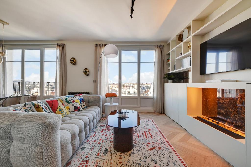 un salon avec un canapé et une cheminée dans l'établissement Penthouse Eiffel view, à Boulogne-Billancourt