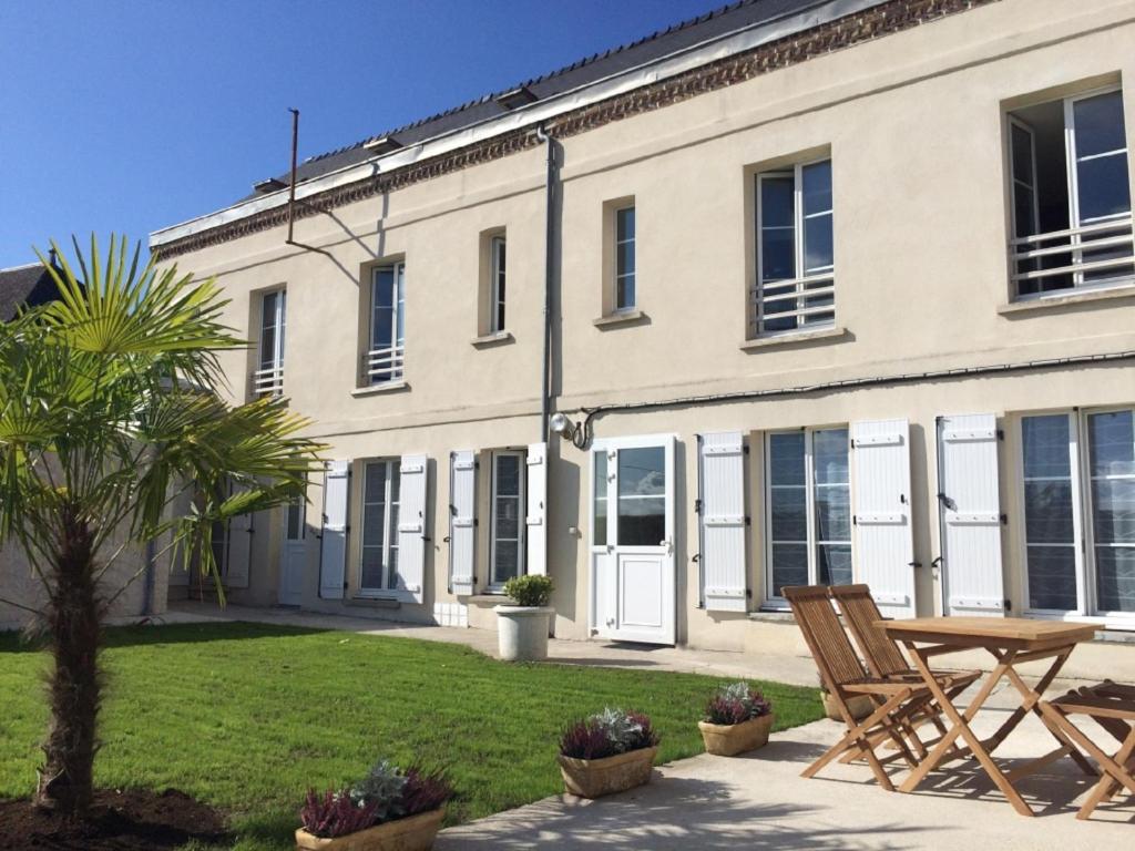 un edificio con una mesa y sillas delante de él en Le Clos Saint Martin en Laon