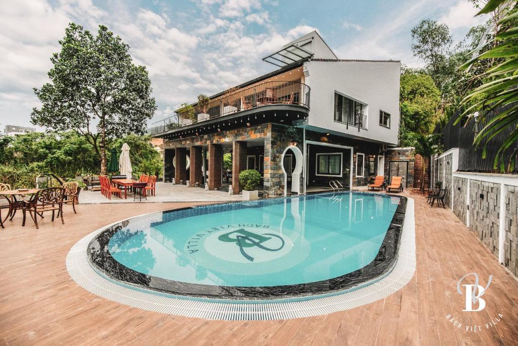 a large swimming pool in front of a house at Bách Việt Villa Retreat Sân Golf Tam Đảo in Tam Ðảo