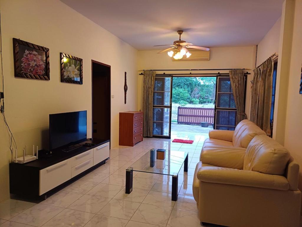a living room with a couch and a flat screen tv at Home in Ban Nong Hin
