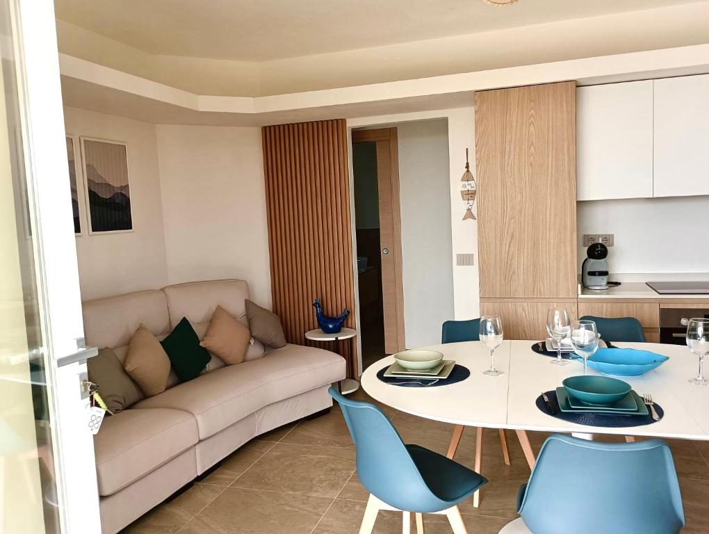 een woonkamer met een bank, een tafel en stoelen bij Elmisa holiday house in Tertenìa