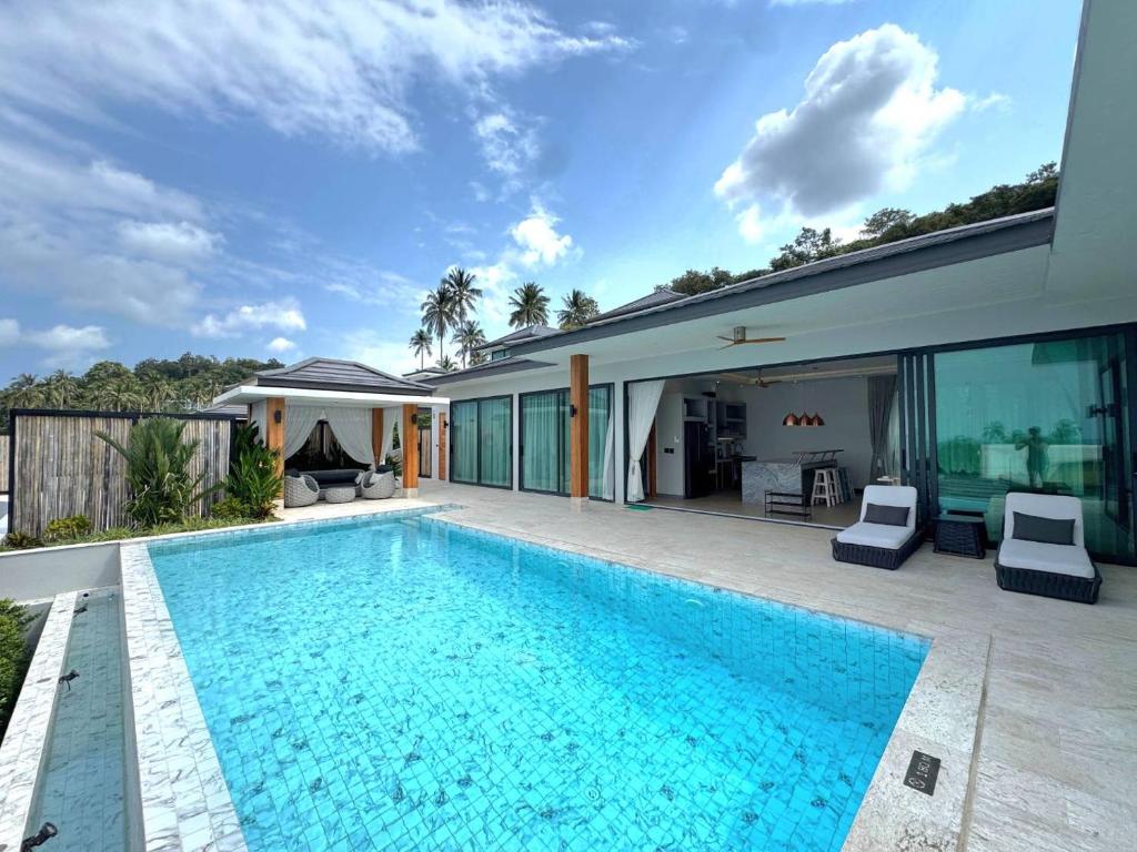 a swimming pool in the backyard of a house at Sunterra villa in Amphoe Koh Samui