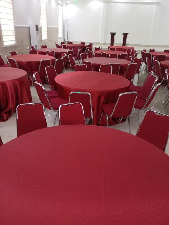 a room filled with red tables and chairs at SkyLine View Hotel in Mama
