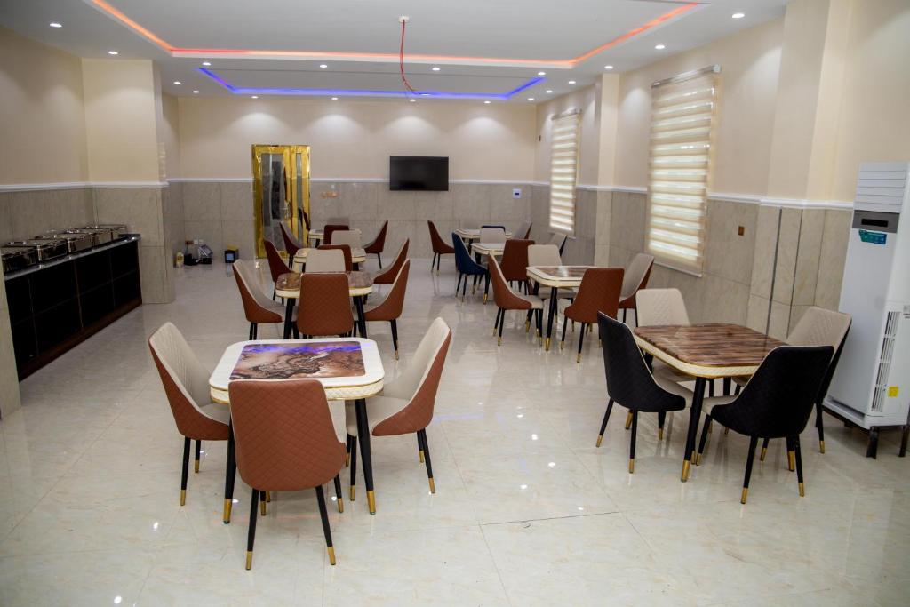 a restaurant with tables and chairs and a tv at SkyLine View Hotel in Mama