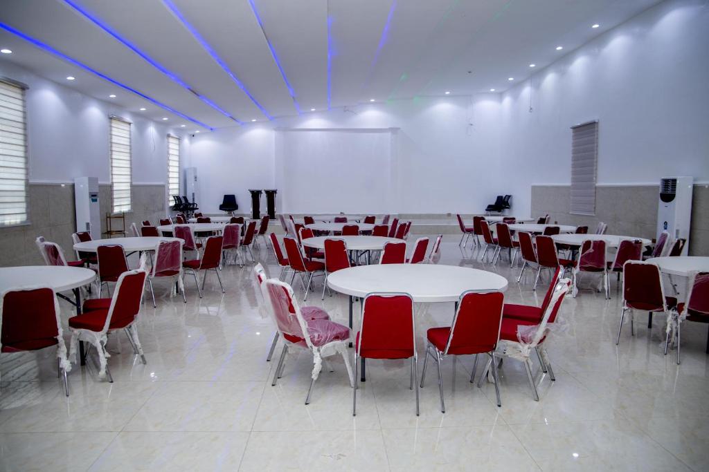 a large room with tables and red chairs at SkyLine View Hotel in Mama