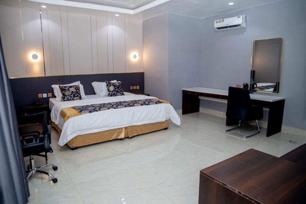 a bedroom with a bed and a desk and a television at SkyLine View Hotel in Mama