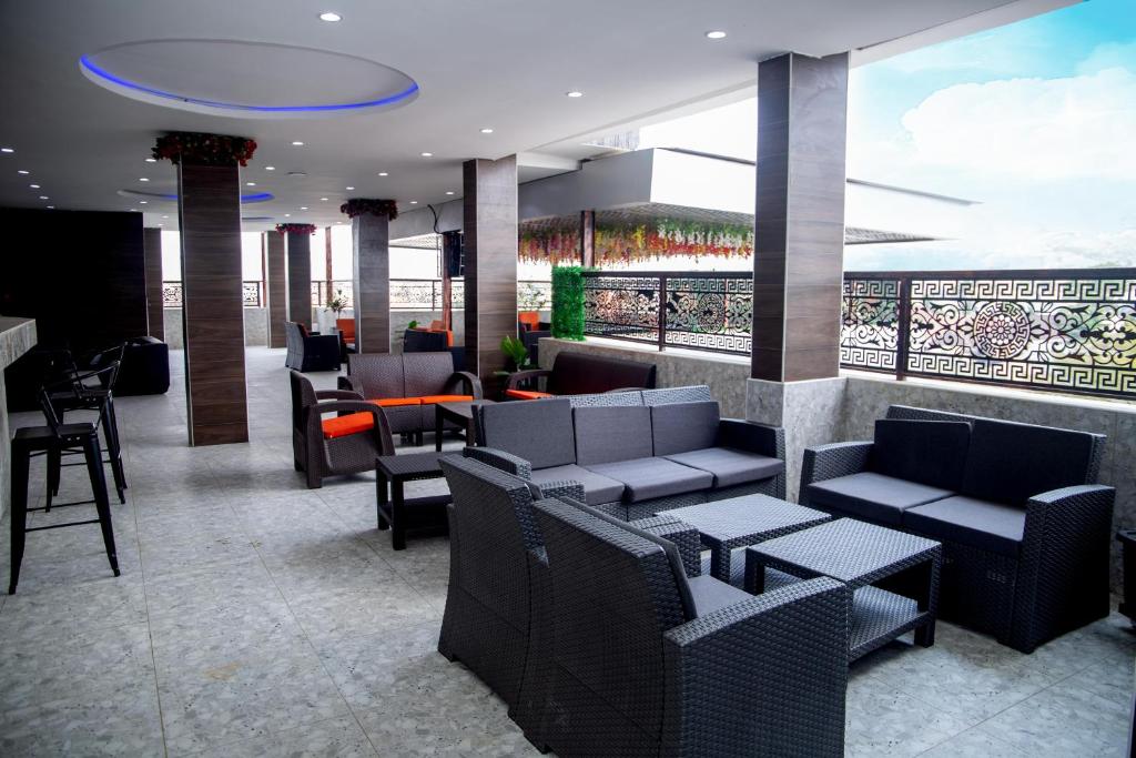 a restaurant with couches and tables and a balcony at SkyLine View Hotel in Mama