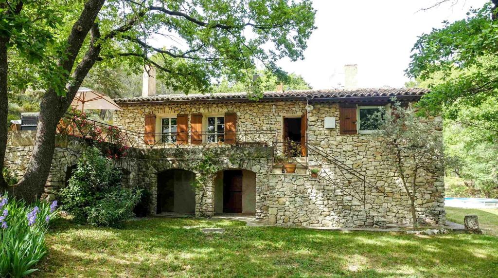 Casa de piedra con balcón en la parte superior. en L'Enclos en Aix-en-Provence