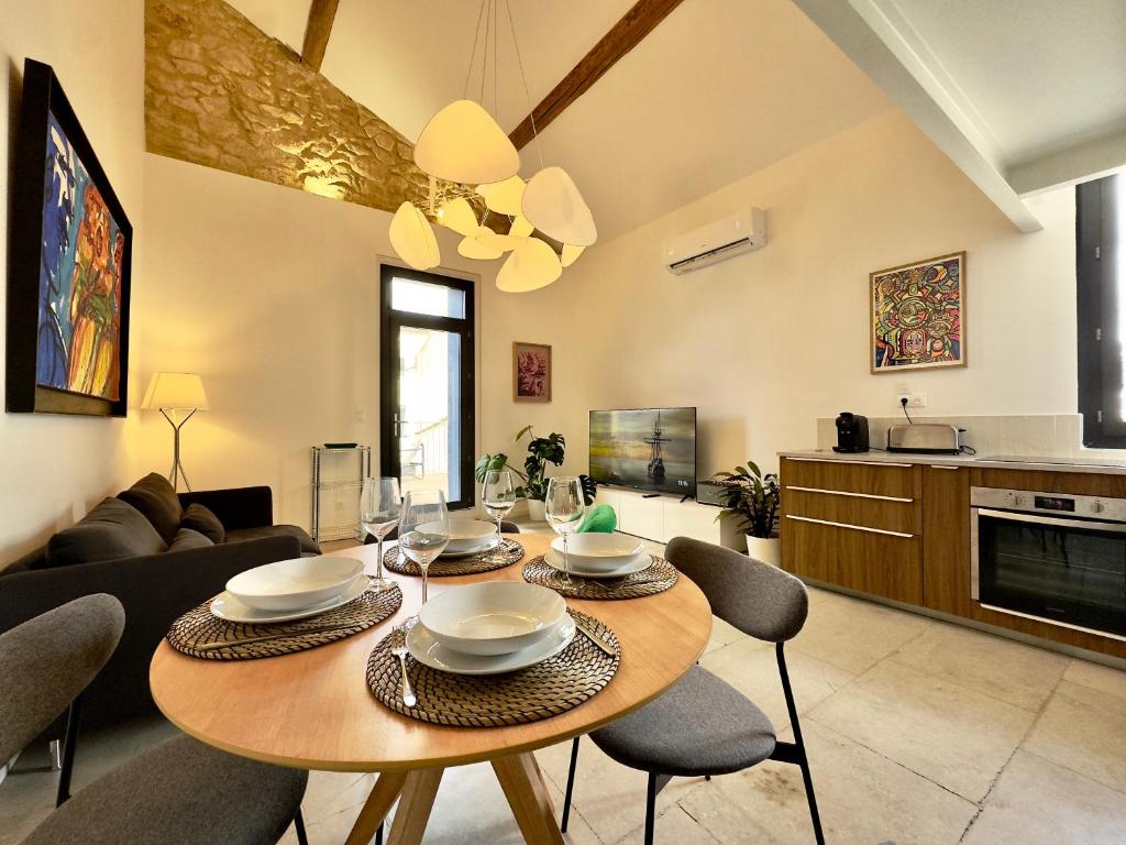 un salon avec une table et des chaises en bois dans l'établissement LOFT - 10 min du centre ville - Terrasse - Parking, à Montpellier