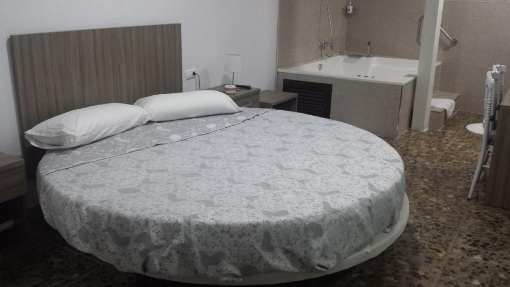 a hotel room with a bed and a table at Alojamiento Jose Carlos in Málaga