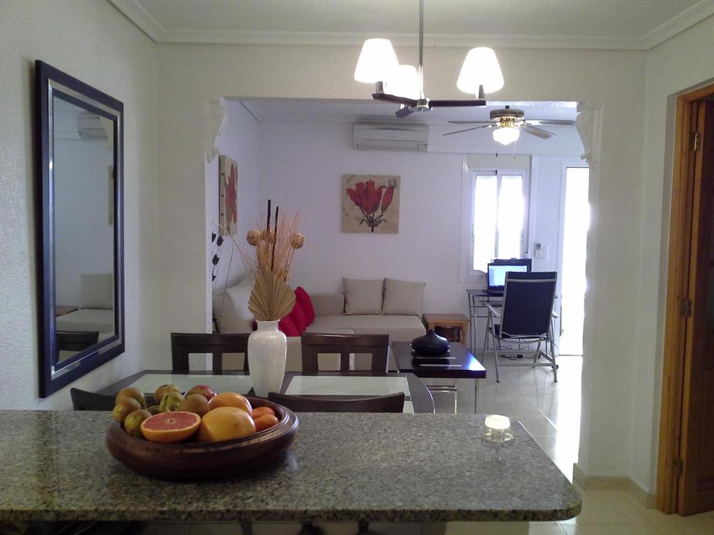 cocina y sala de estar con un plato de fruta en una mesa en Apartment 241, en Gran Alacant