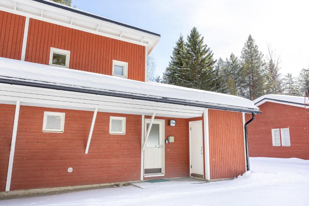 ブオカッティにあるLomakatti Apartmentsの雪中白い扉付き赤い家