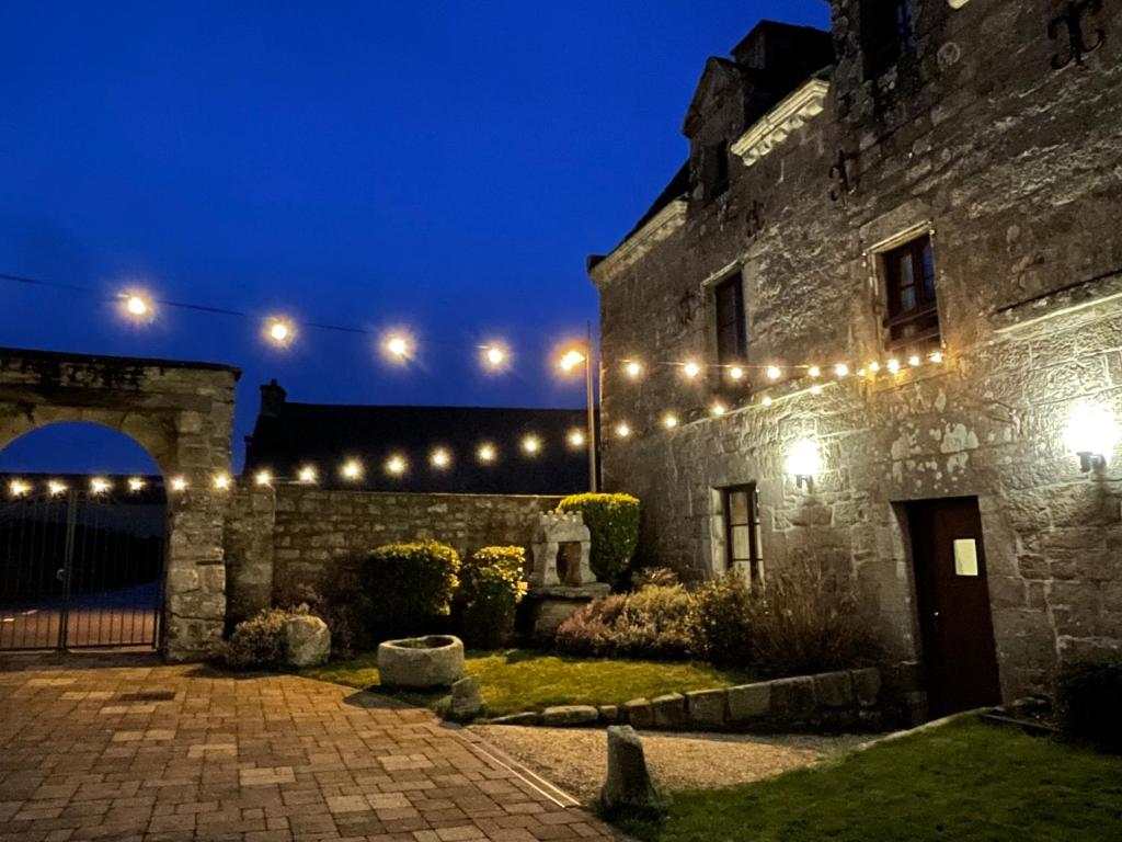 an old stone building with lights on it at night at Gîte et Hostel Le Ty Bihui in Bieuzy-les Eaux
