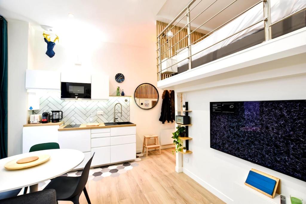 a kitchen and living room with a table and a staircase at Hyper-Centre Studio Lekain UnSejourANantes in Nantes