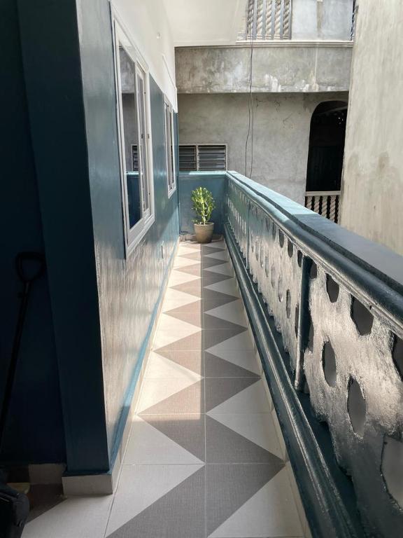 ein Balkon mit einer Topfpflanze an der Seite eines Gebäudes in der Unterkunft Fassinou in Cotonou