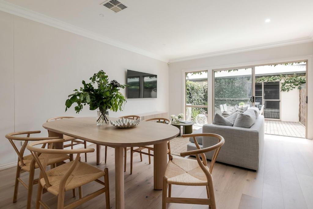 ein Wohnzimmer mit Tisch und Stühlen und einer Couch in der Unterkunft Adelaide Oval Townhouse - Walk to the AFL & CBD in North Adelaide