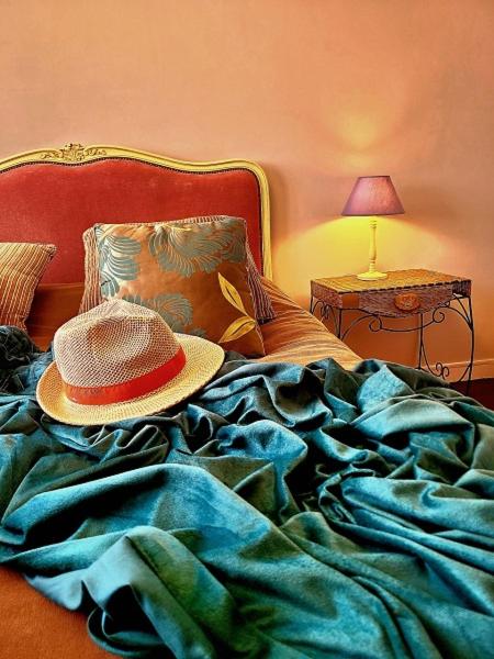 un chapeau assis au-dessus d'un lit dans l'établissement La Casa Sylvia, 6 pers WIFI, à Boulogne-sur-Mer