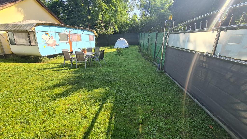 een tuin met een tent en een tafel en stoelen bij Erlebe unseren Verein im geräumigen Wohnwagen! in Feldkirchen bei Graz