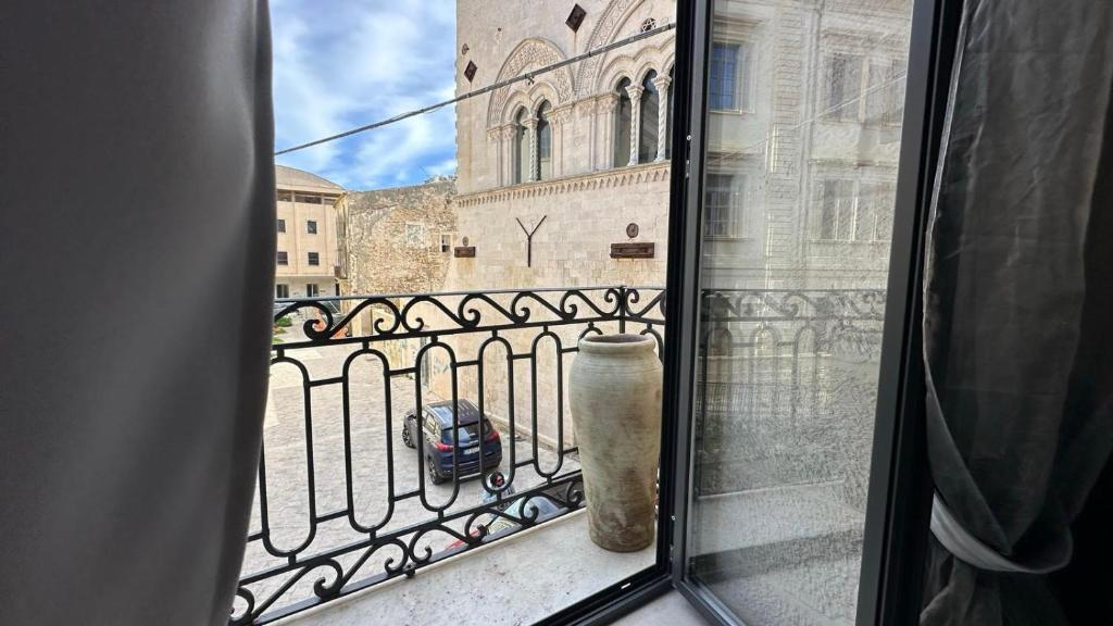 Una ventana con vista a un edificio y un coche. en Montalto Luxury House, en Siracusa
