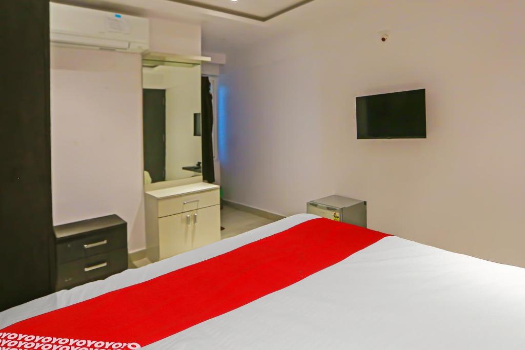 a bedroom with a large bed with a red blanket at Super Hotel O Botcha Convection in Visakhapatnam