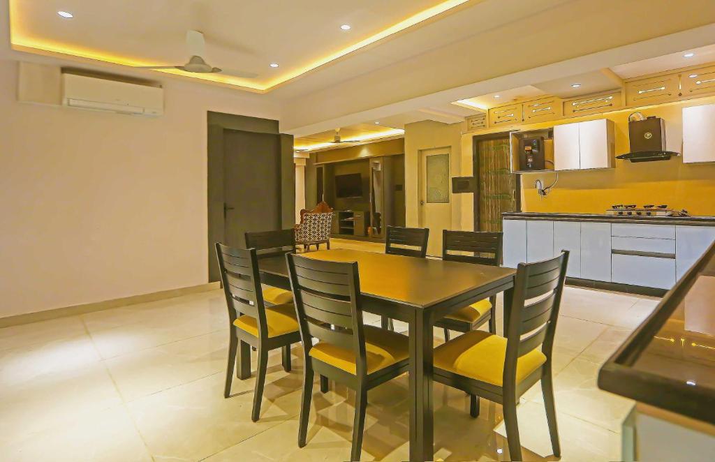 a dining room and kitchen with a table and chairs at Super Hotel O Botcha Convection in Visakhapatnam