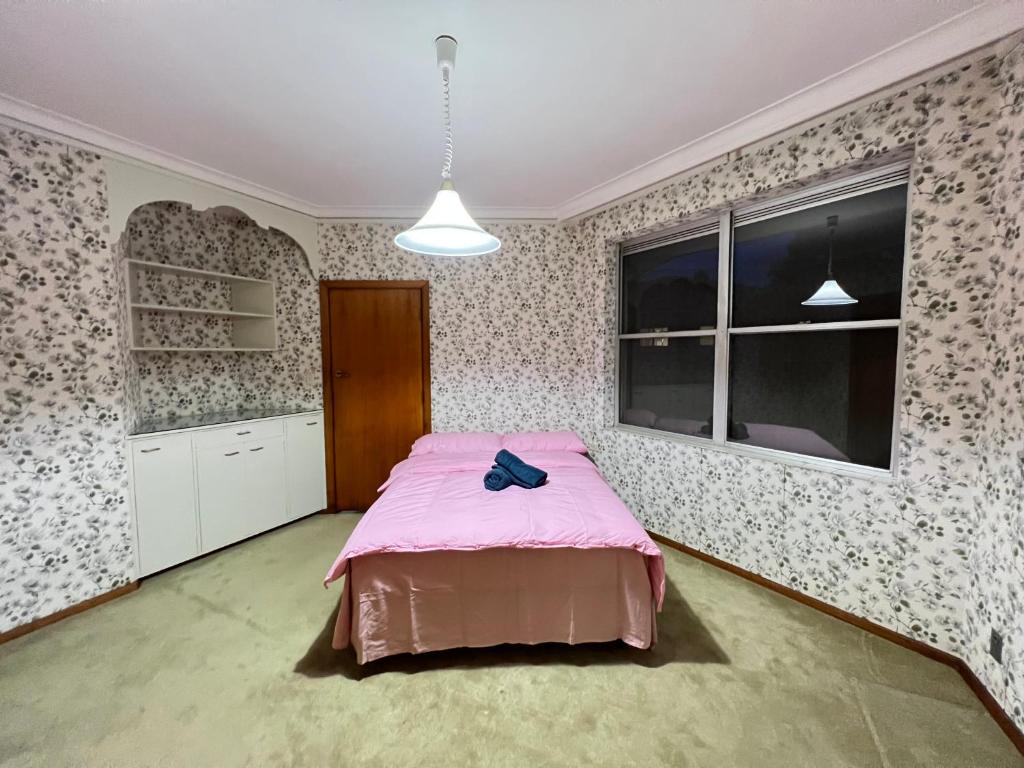 Epping31 Room的带粉色床和窗户的卧室