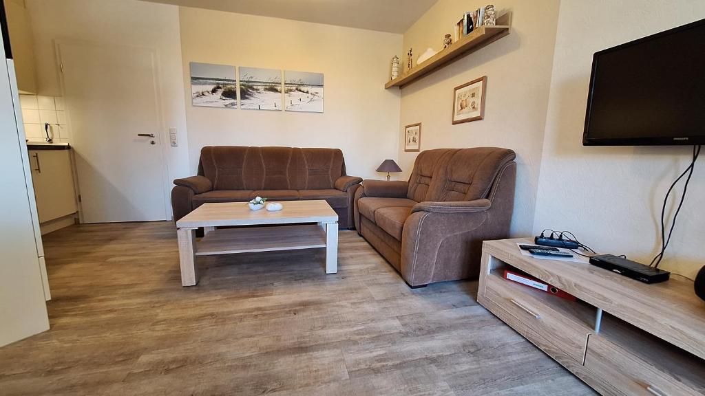 a living room with two couches and a coffee table at Ferienwohnung Boje 6 in Schillig