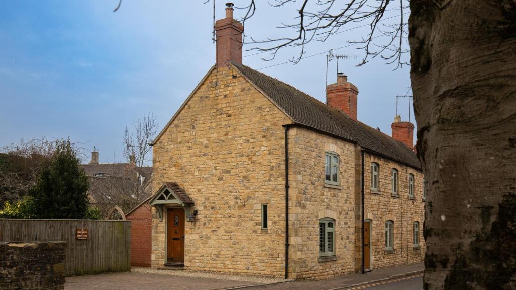 stary ceglany budynek z kominem na górze w obiekcie Crafty Cottage w mieście Chipping Campden