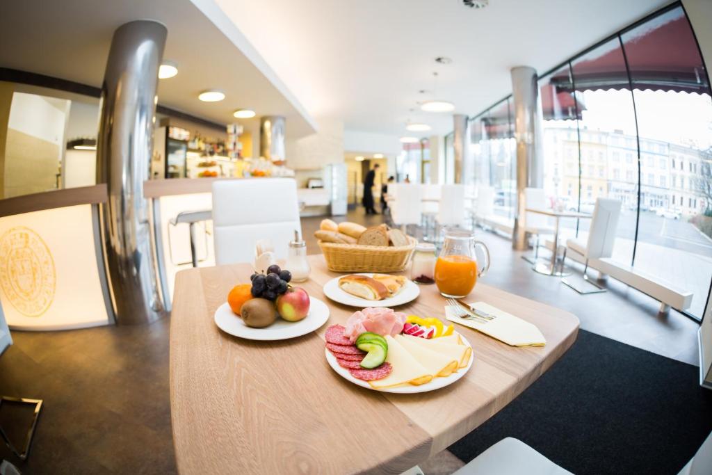 una mesa con platos de fruta y zumo. en Hotel Koruna, en Opava