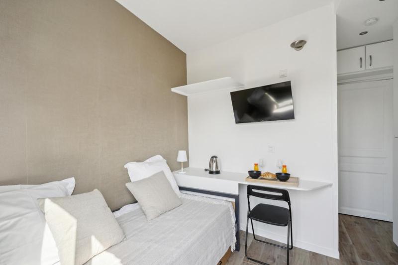 une chambre blanche avec un lit et un bureau dans l'établissement 505 Suite Mozart 2 - Cosy studio in Paris 16th, à Paris