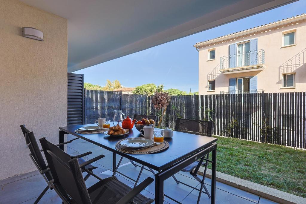 une table avec de la nourriture dessus sur une terrasse dans l'établissement Casa Kenez - A 5min de la plage, à Cavalaire-sur-Mer