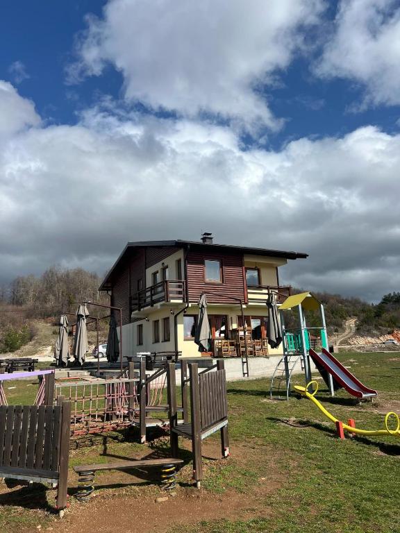 a house with a playground in front of it at Resort Stari Bagrem Tvrdimici in Tvrdimići