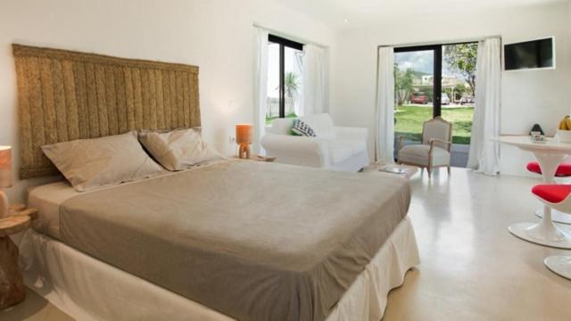 a bedroom with a large bed and a living room at charming studio in the house of Envi's house in Sant Josep