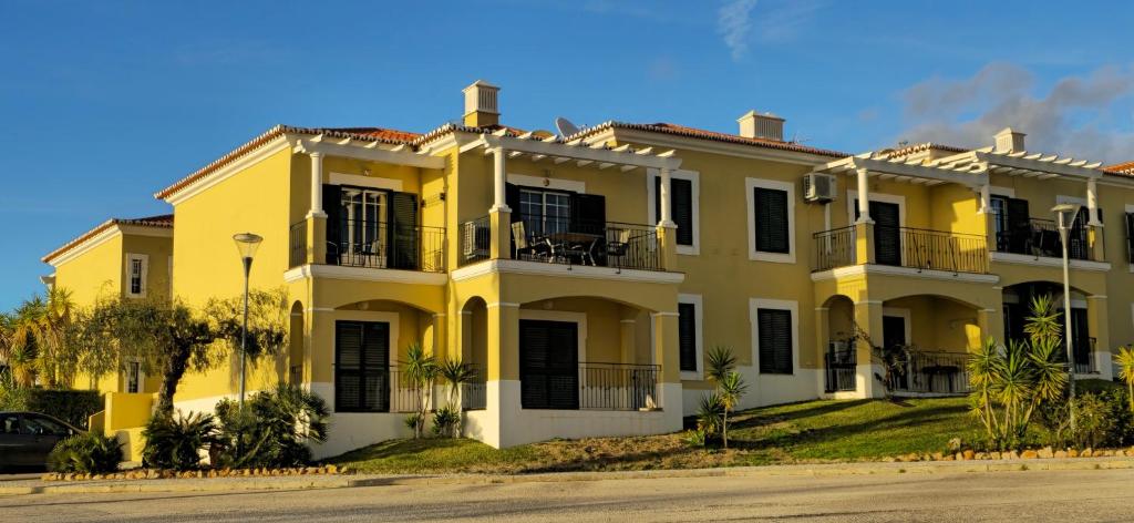 a yellow building with black doors and windows at Sunset Apartment in Porches
