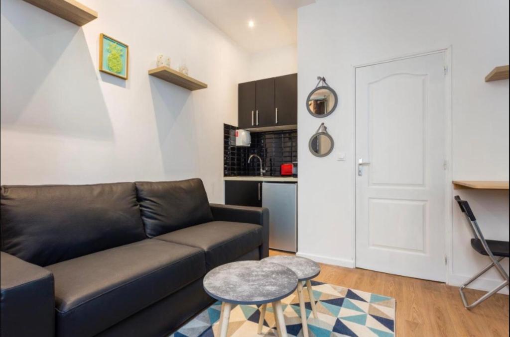 un salon avec un canapé et une table dans l'établissement 1 Cozy studio Père Lachaise Nation, à Paris