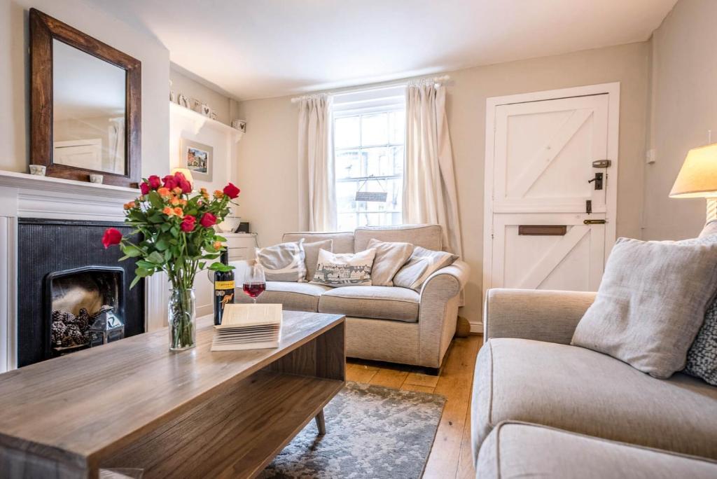 een woonkamer met een salontafel en een open haard bij Shrimpers, Southwold in Southwold