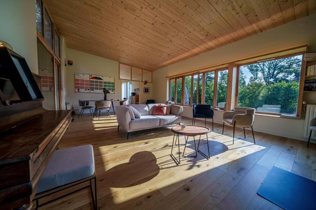 un salon avec un canapé et une table dans l'établissement Elégante maison 225 m2, au Vert, 10 personnes, 5 chambres, 5 salles de bain, à Saint-Bonnet-le-Chastel
